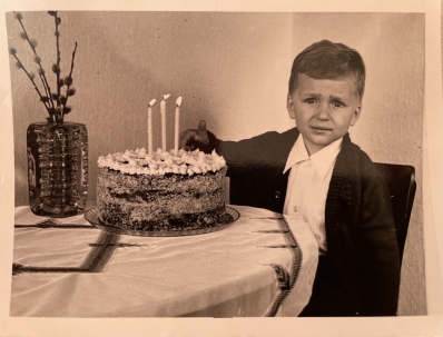 A person sitting at a table with a cake 